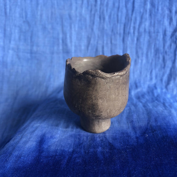 Petit pot en terre cuite sombre, forme bulbeuse, bord irrégulier