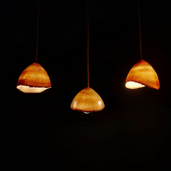 Suspension en frêne : trois abat-jours demi-lune en bois, lumière chaude