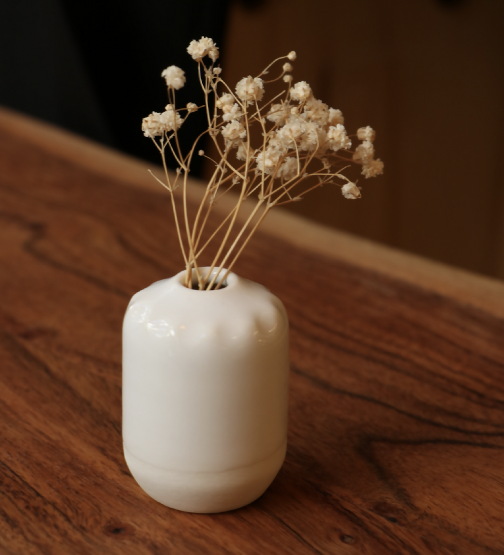 Mini-vase en porcelaine blanche brillante, forme arrondie, ouverture étroite.
