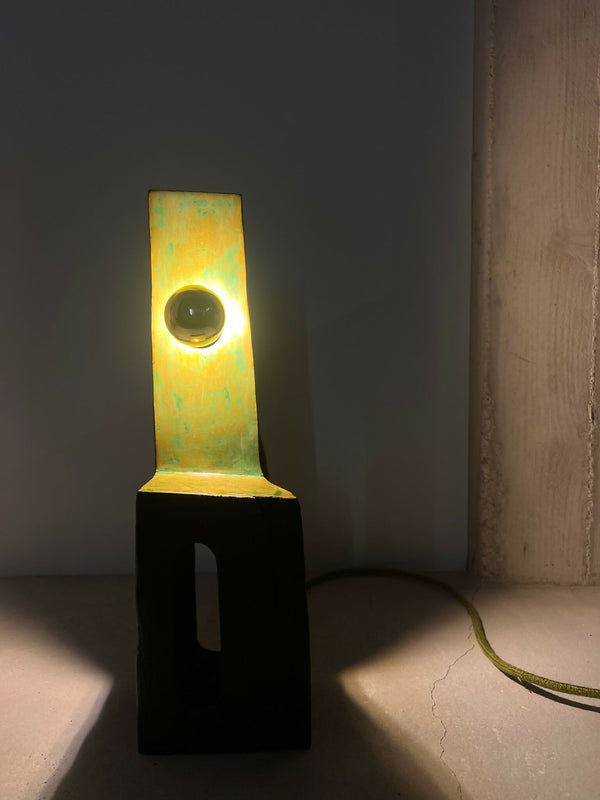 Totem lumineux rectangulaire vert et jaune, base noire, ouverture ronde centrale