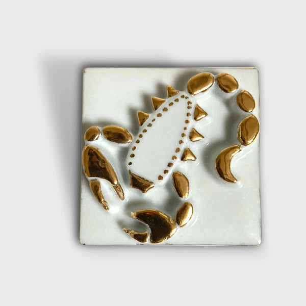 Boîte à bijoux en porcelaine carrée, décor scorpion doré et blanc sur le couvercle.