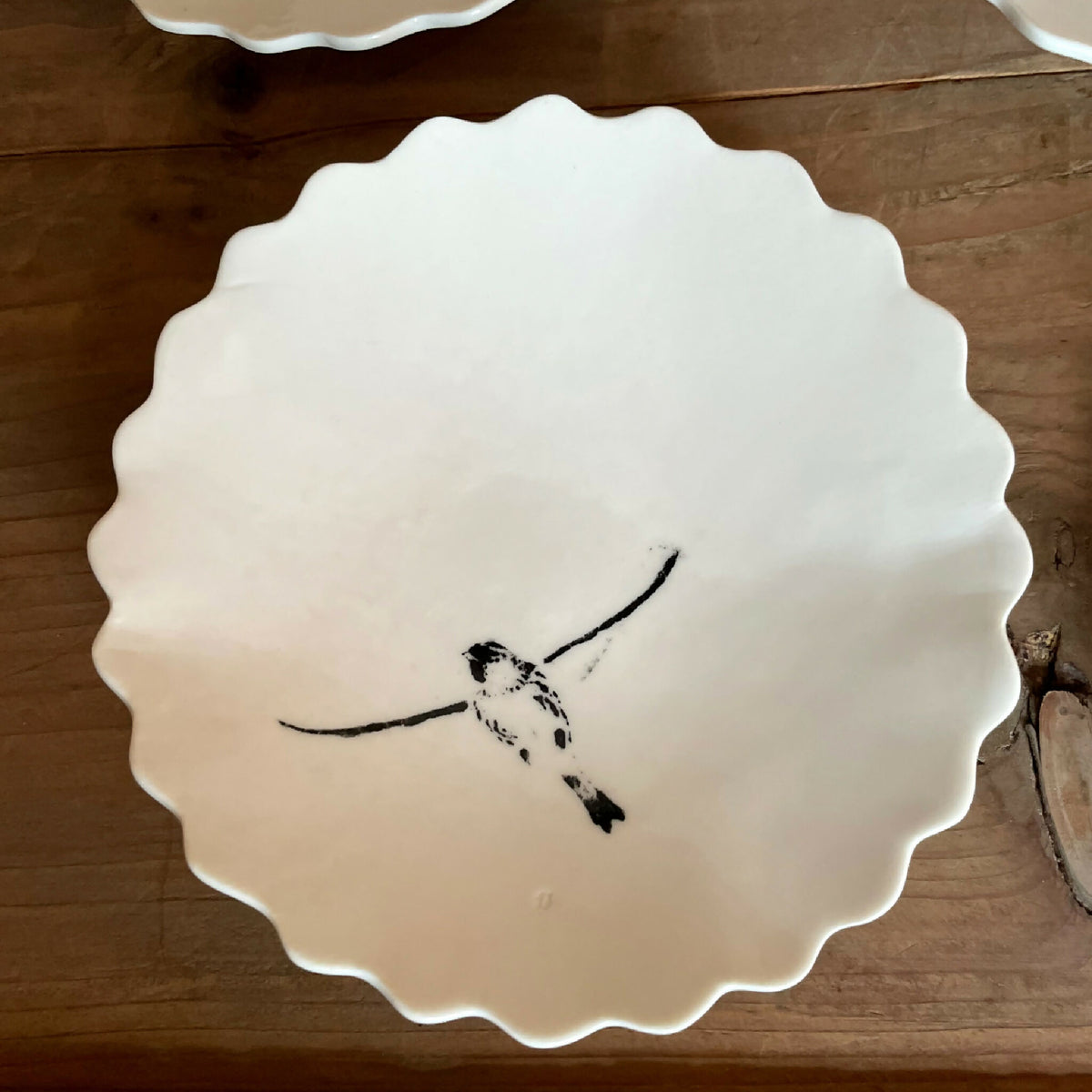 Coupelle en porcelaine blanche, bord festonné, oiseau noir posé, décor artisanal peint