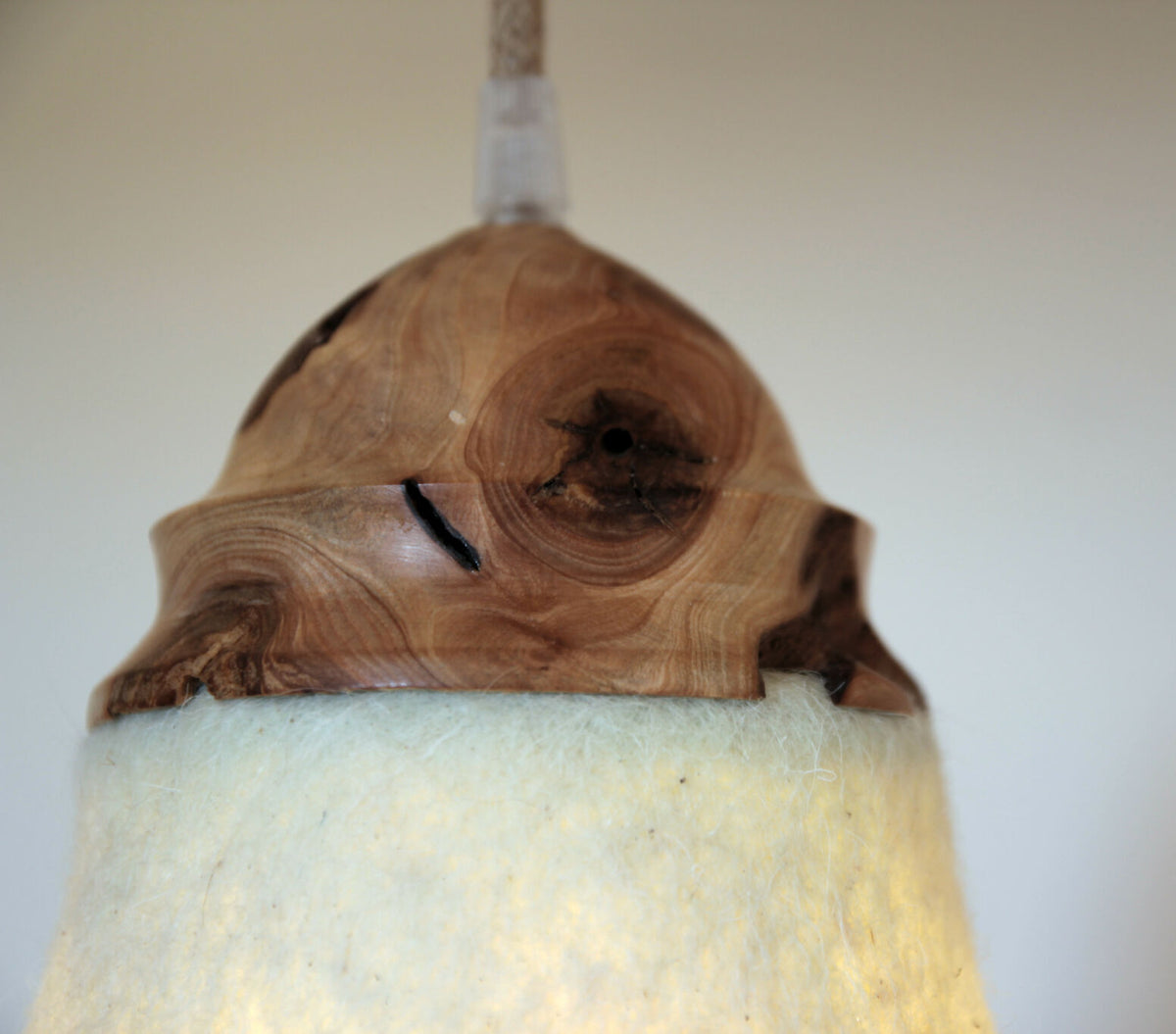 Suspension : couronne en bois brun sculpté au grain, sur abat-jour en feutre beige