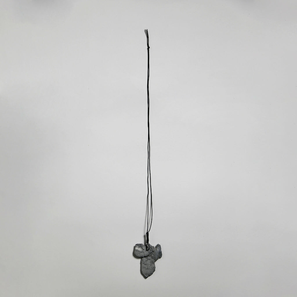 Pendentif gris en forme de fleur, suspendu sur cordon fin