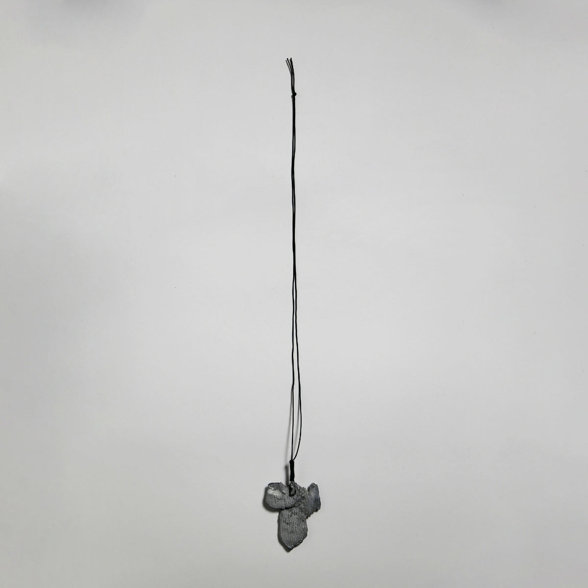 Pendentif gris en forme de fleur, suspendu sur cordon fin
