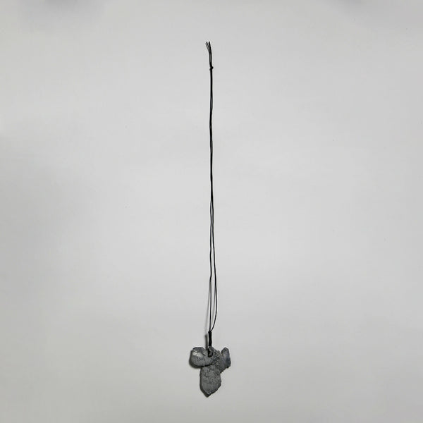 Pendentif gris en forme de fleur, suspendu sur cordon fin