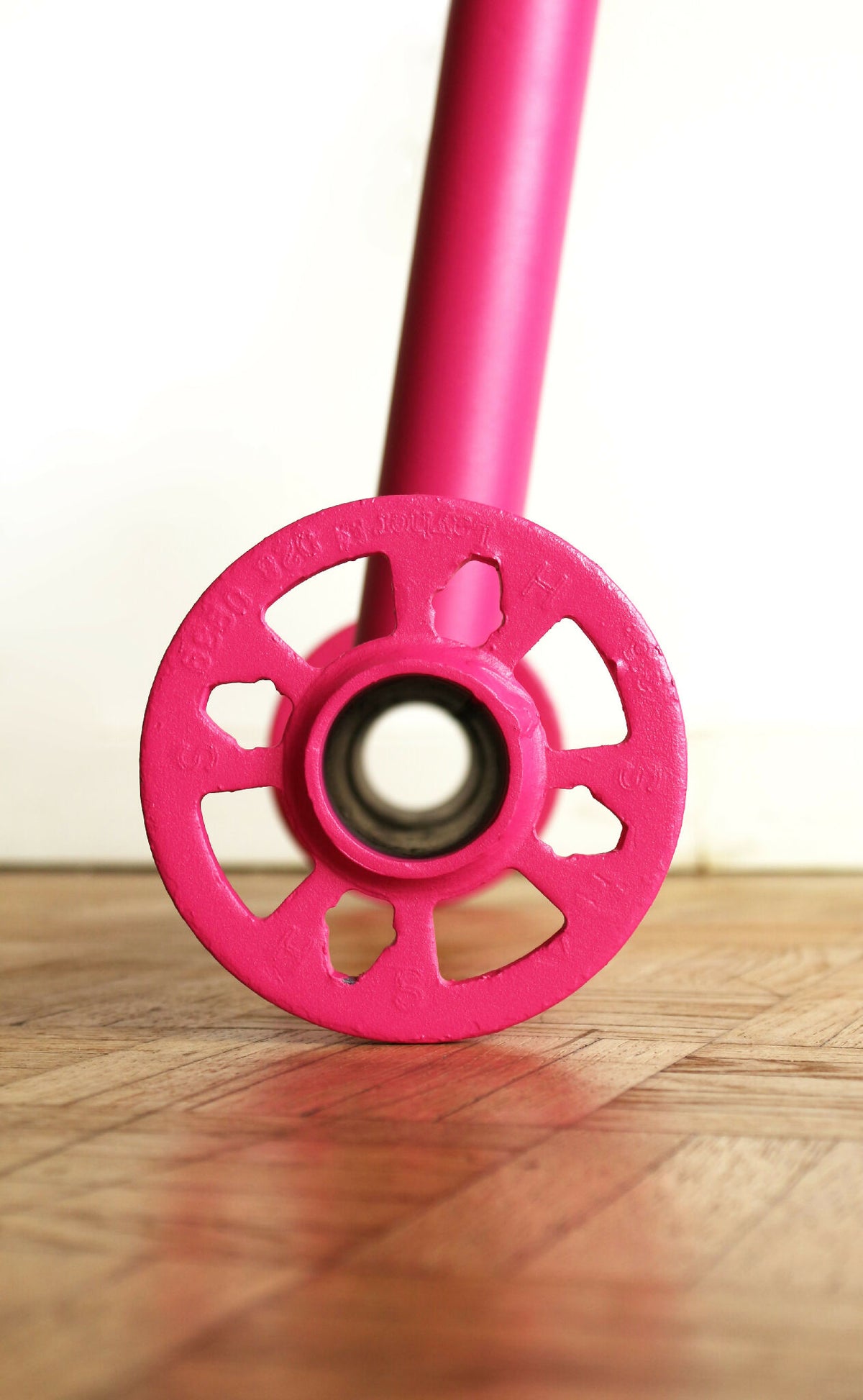 Lampe UMARELL Ettore rose, roue de trépied en détail sur parquet