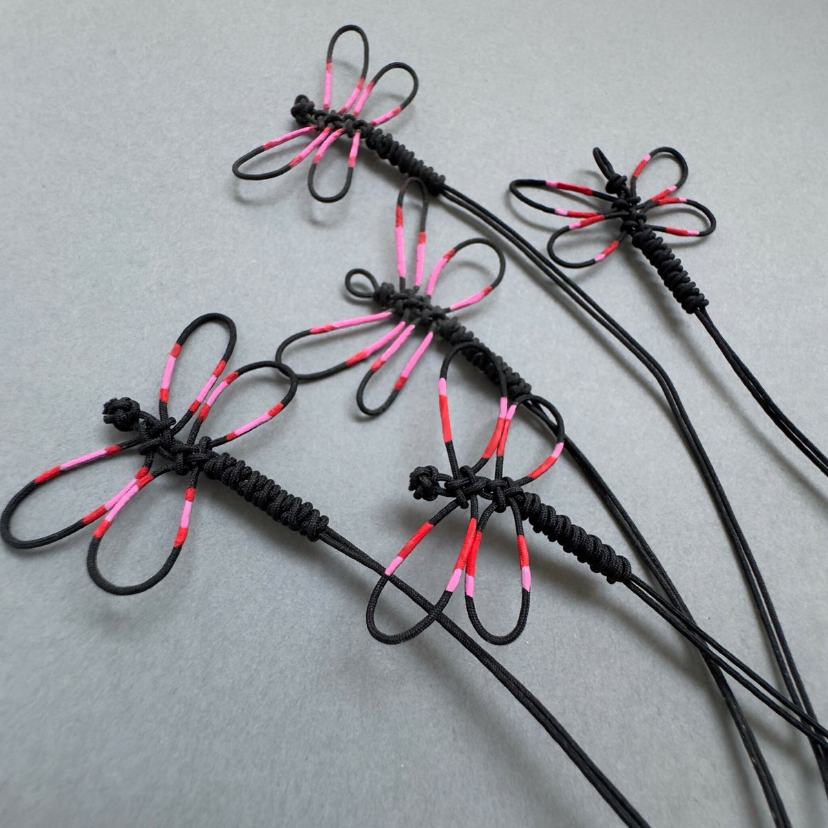 Bracelets noirs à motif de libellule rose et rouge, ensemble de plusieurs modèles.