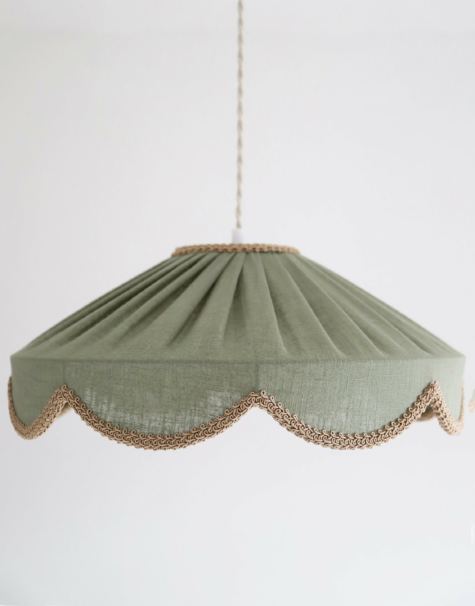 Suspension abat-jour textile vert sauge, fronces marquées et liseré ajouré doré