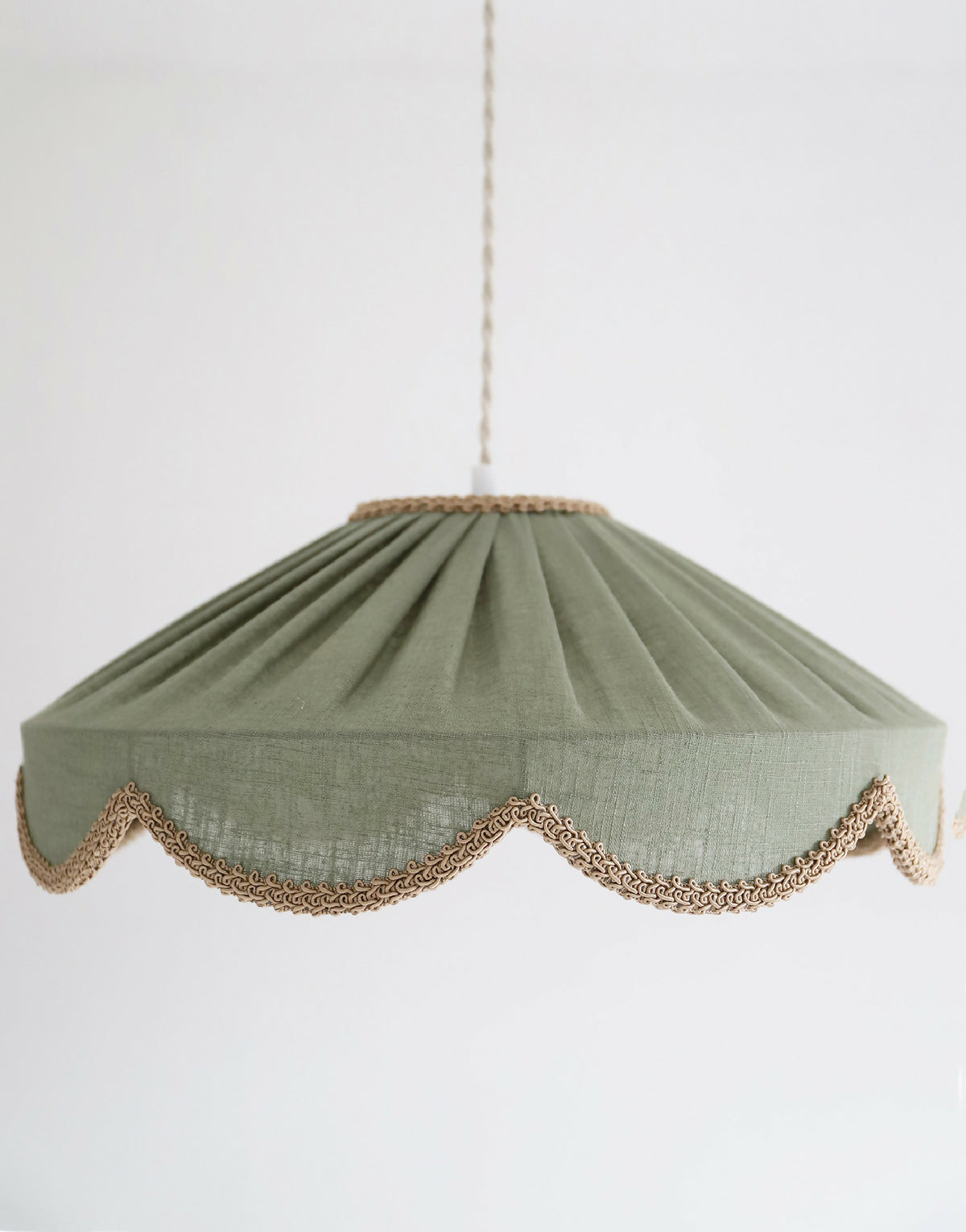 Suspension abat-jour textile vert sauge, fronces marquées et liseré ajouré doré