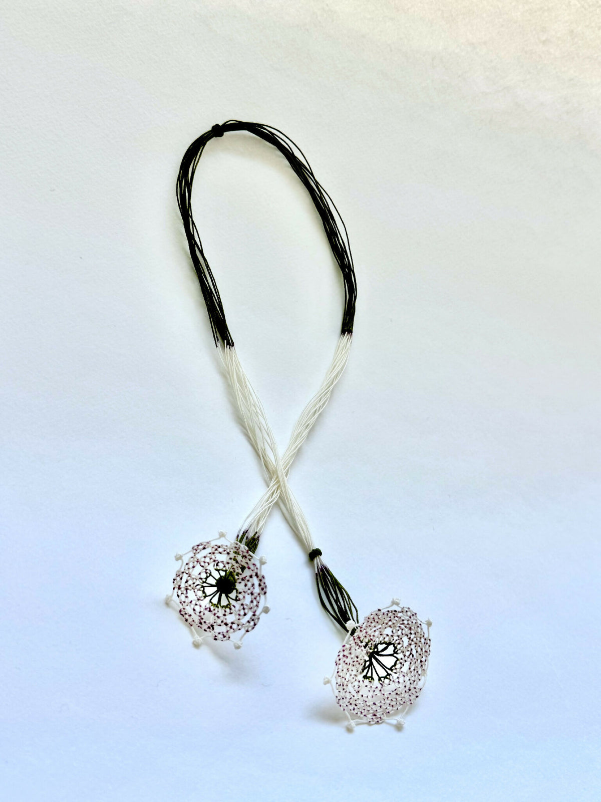 Collier en soie avec deux pendentifs trèfle argentés et cordons bicolores