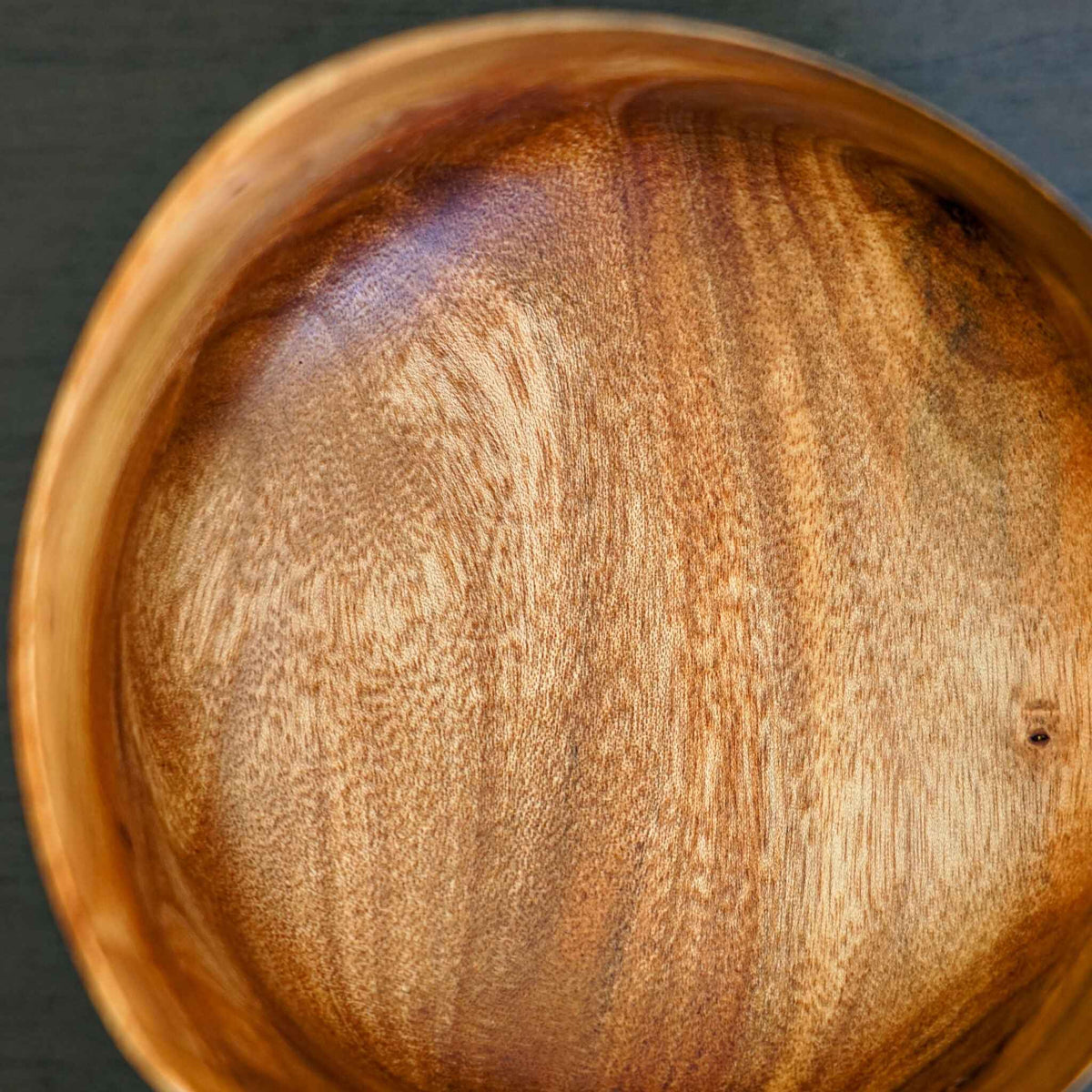 Bol en bois « vague » brun, gros plan sur le veinage et un nœud