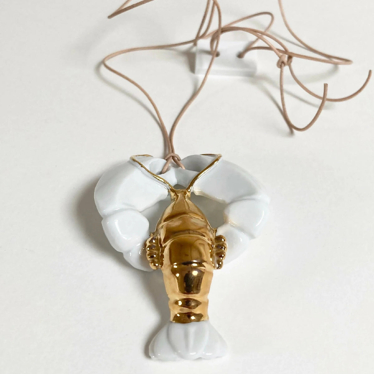 Sautoir homard doré avec pendentif doré et pinces blanches, cordons noués