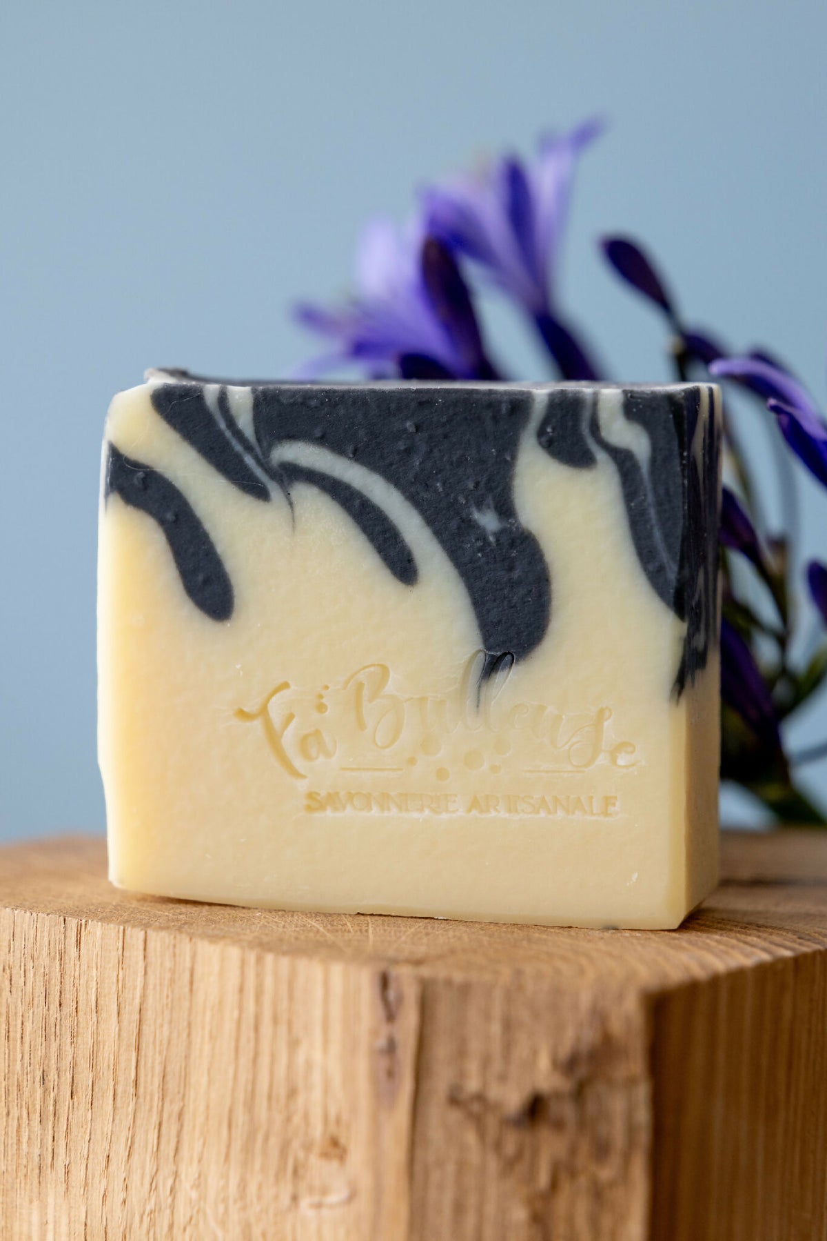 Savon solide au charbon actif et karité, barre crème avec marbrures noires.
