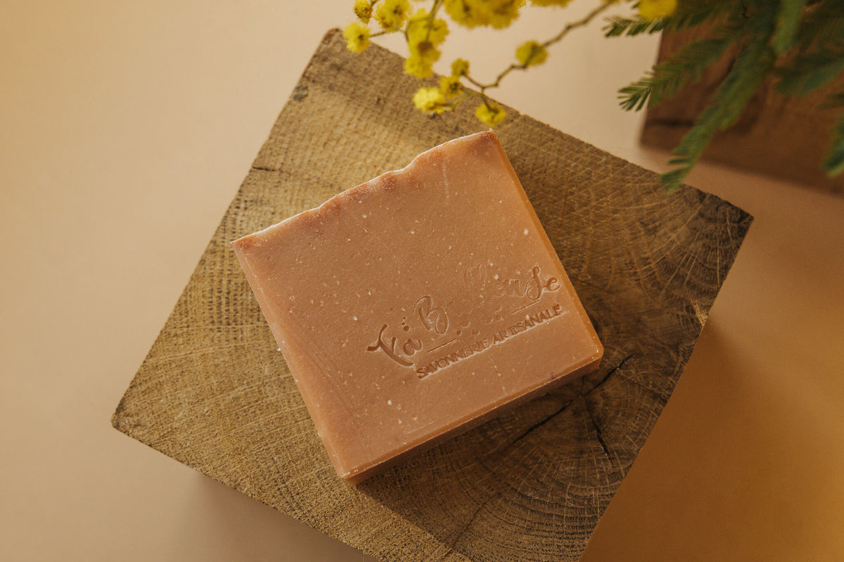 Savon en barre rose sur toile de jute, marque gravée sur le côté.