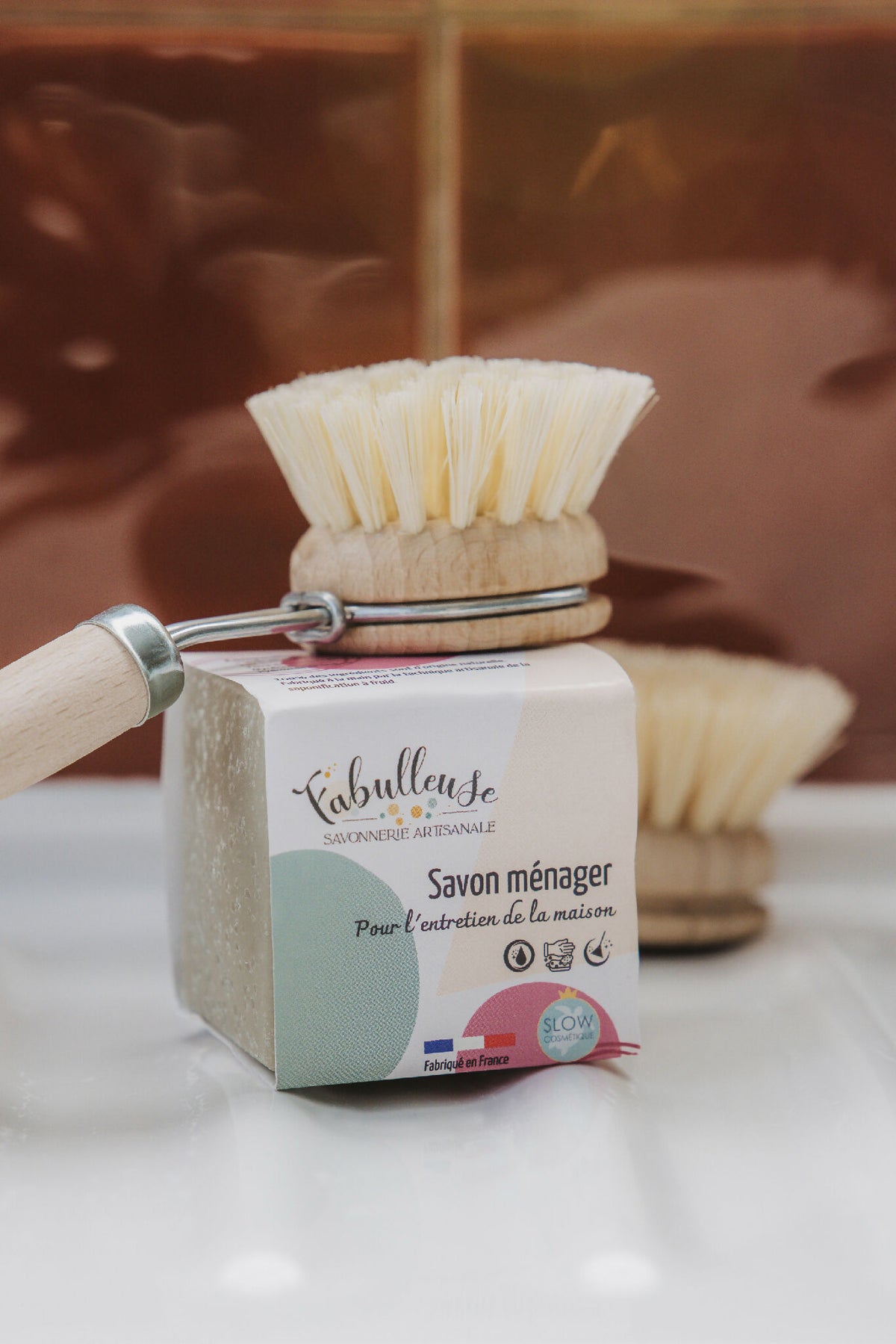 Savon ménager en barre avec brosse à récurer sur le dessus, étiquette blanche