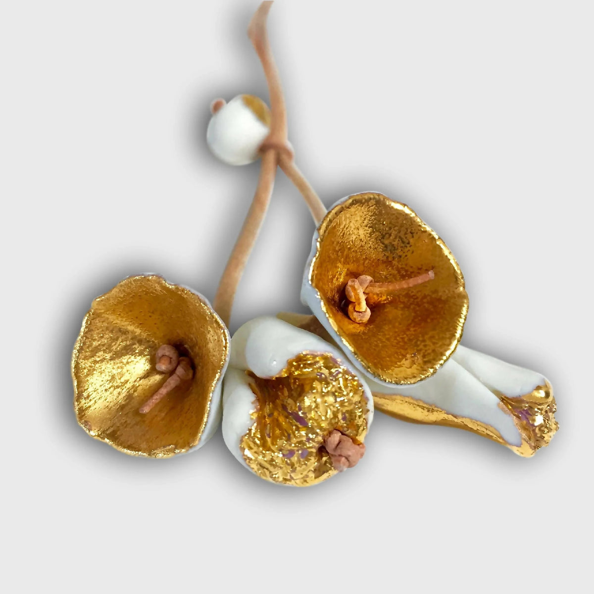Collier avec fleurs pendantes dorées, pétales texturés et perles blanches.