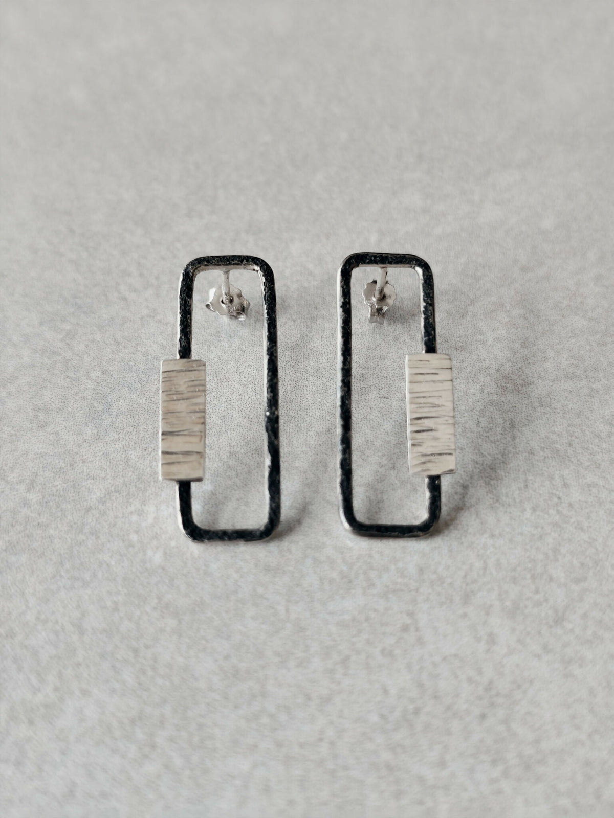 Boucles d’oreilles rectangulaires métal argenté, contours foncés et plaque texturée