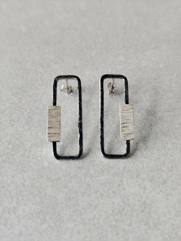 Boucles d’oreilles rectangulaires métal argenté, contours foncés et plaque texturée