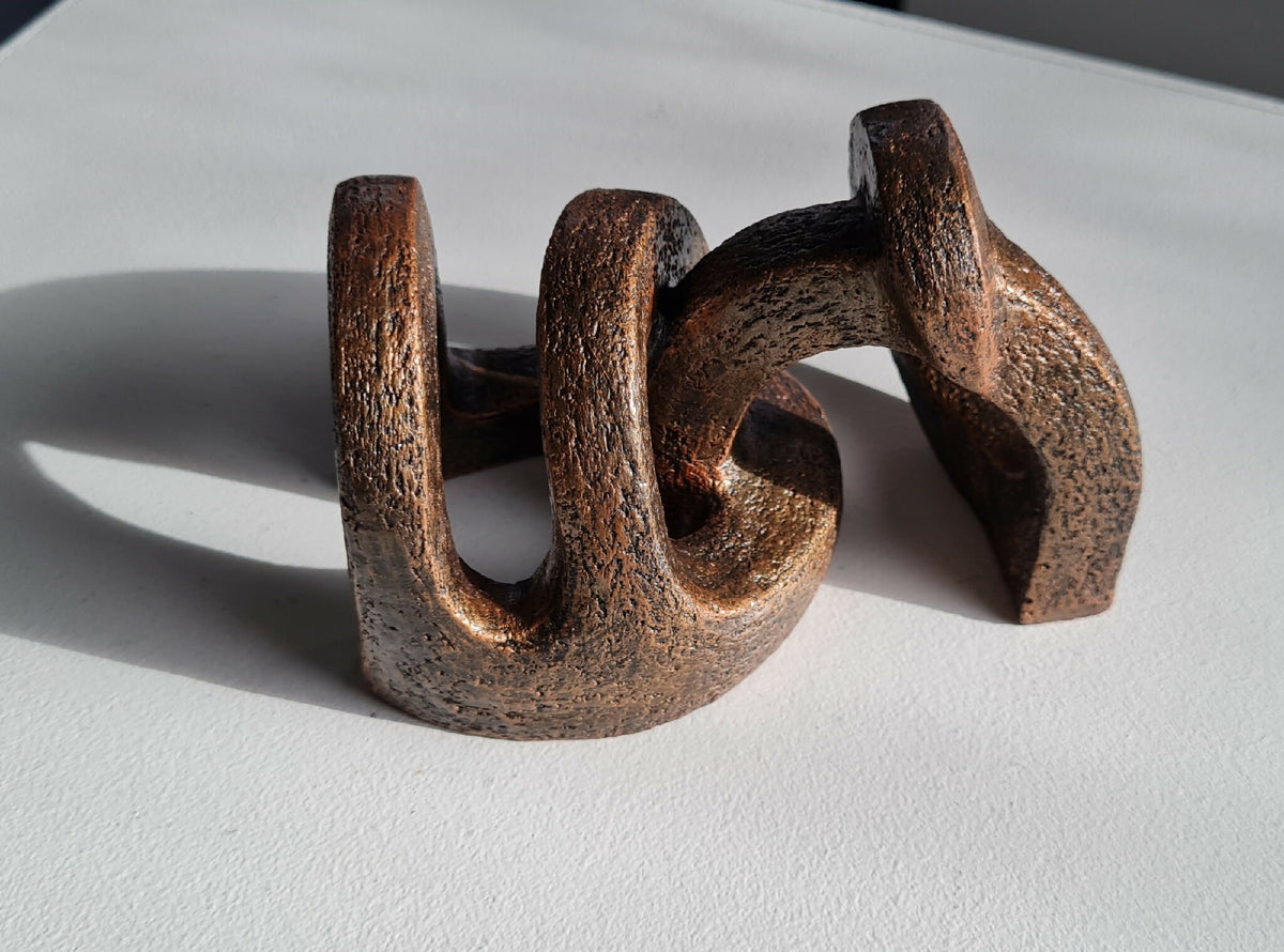 Sculpture abstraite en bois brun foncé, arches courbées, vue de côté