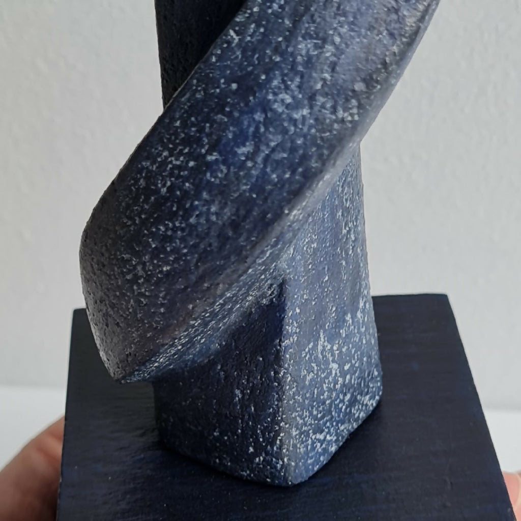Sculpture couple en résine texturée, vue rapprochée de la posture sur socle