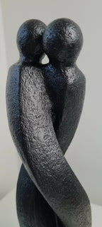 Sculpture en argile sombre : vue rapprochée de deux personnages qui se tiennent