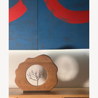 Sculpture en bois avec base florale et médaillon rond illustrant un arbre