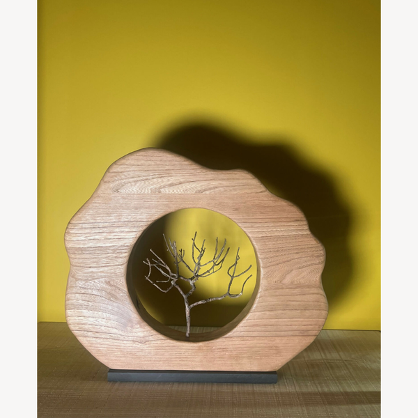 Sculpture en bois florale beige avec médaillon rond et arbre gravé sur fond sombre