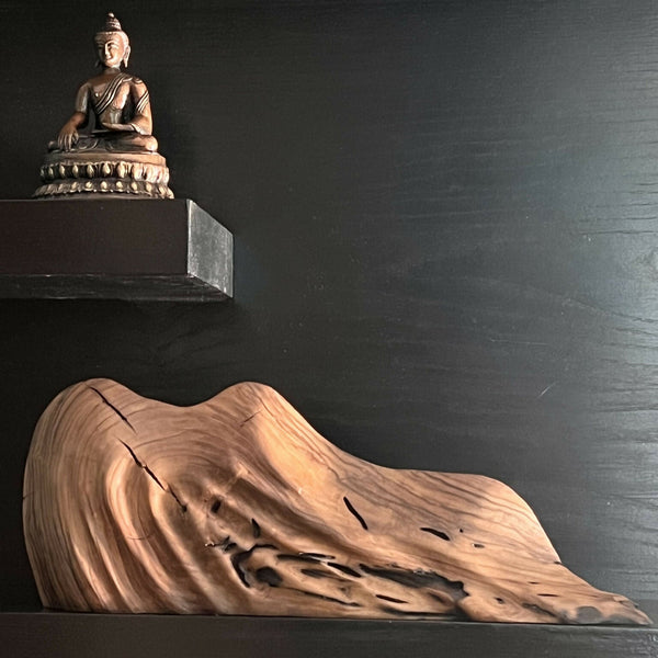 Sculpture abstraite allongée, surface texturée couleur bois, avec base sombre