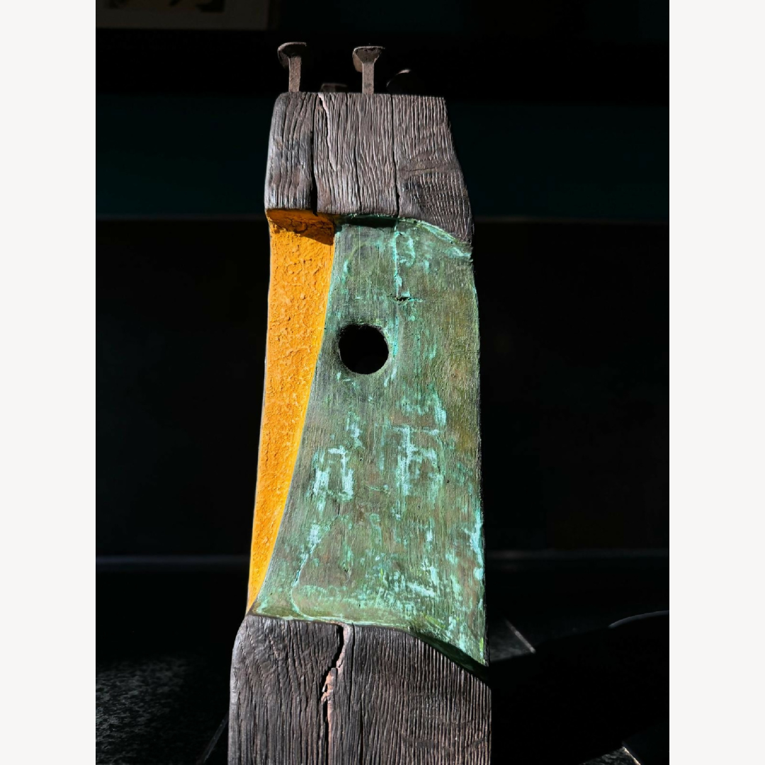 Statue totem décorative en métal patiné, colonne empilée, trou circulaire au centre.