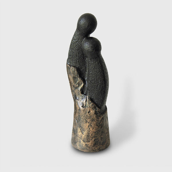 Sculpture couple en résine, deux silhouettes noires et dorées, sur socle arrondi.