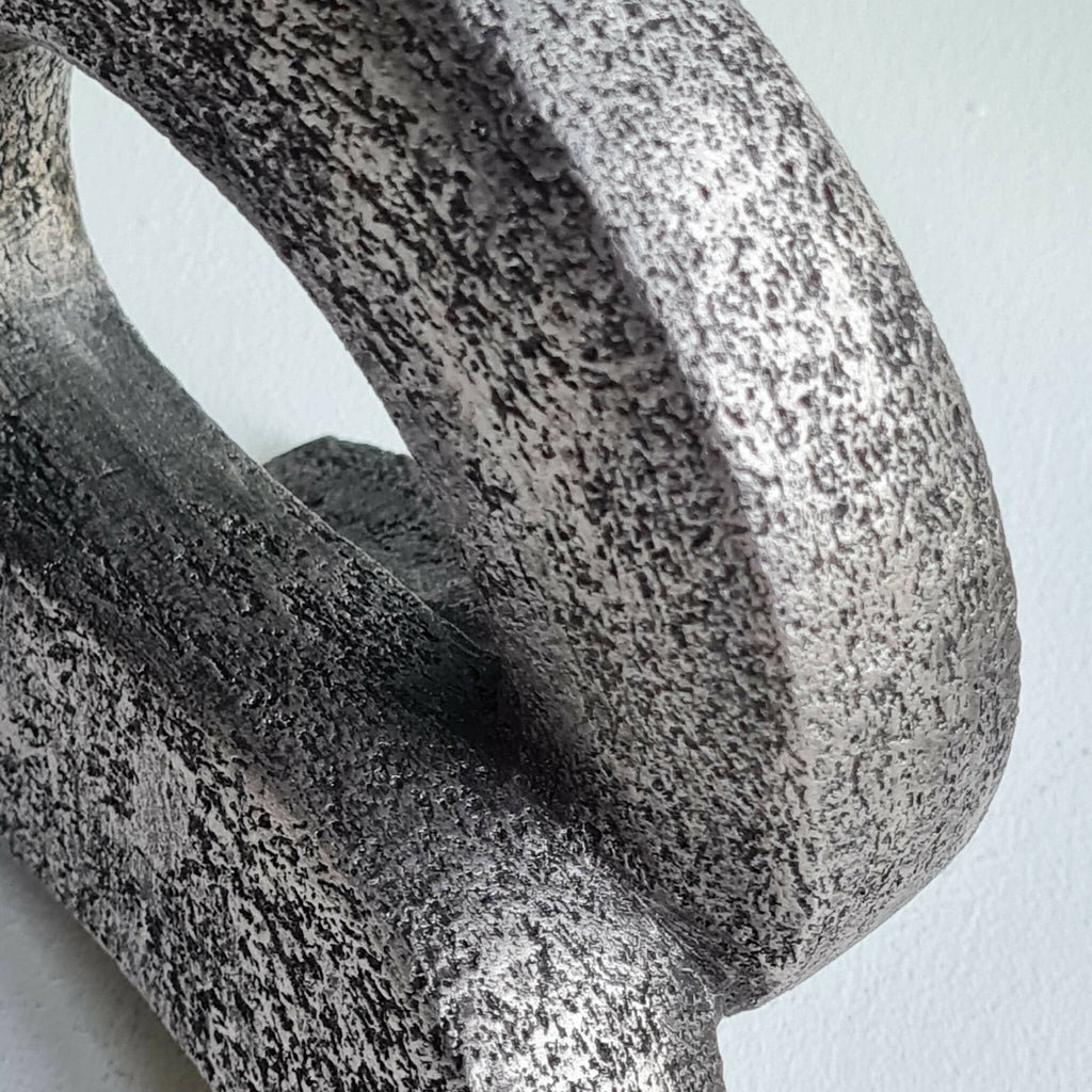 Sculpture en pierre sombre, détail de surface texturée autour de l’ouverture