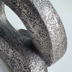 Sculpture en pierre sombre, détail de surface texturée autour de l’ouverture
