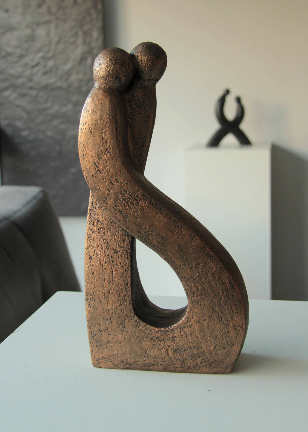 Sculpture abstraite en bronze patiné, figures enlacées dressées sur socle