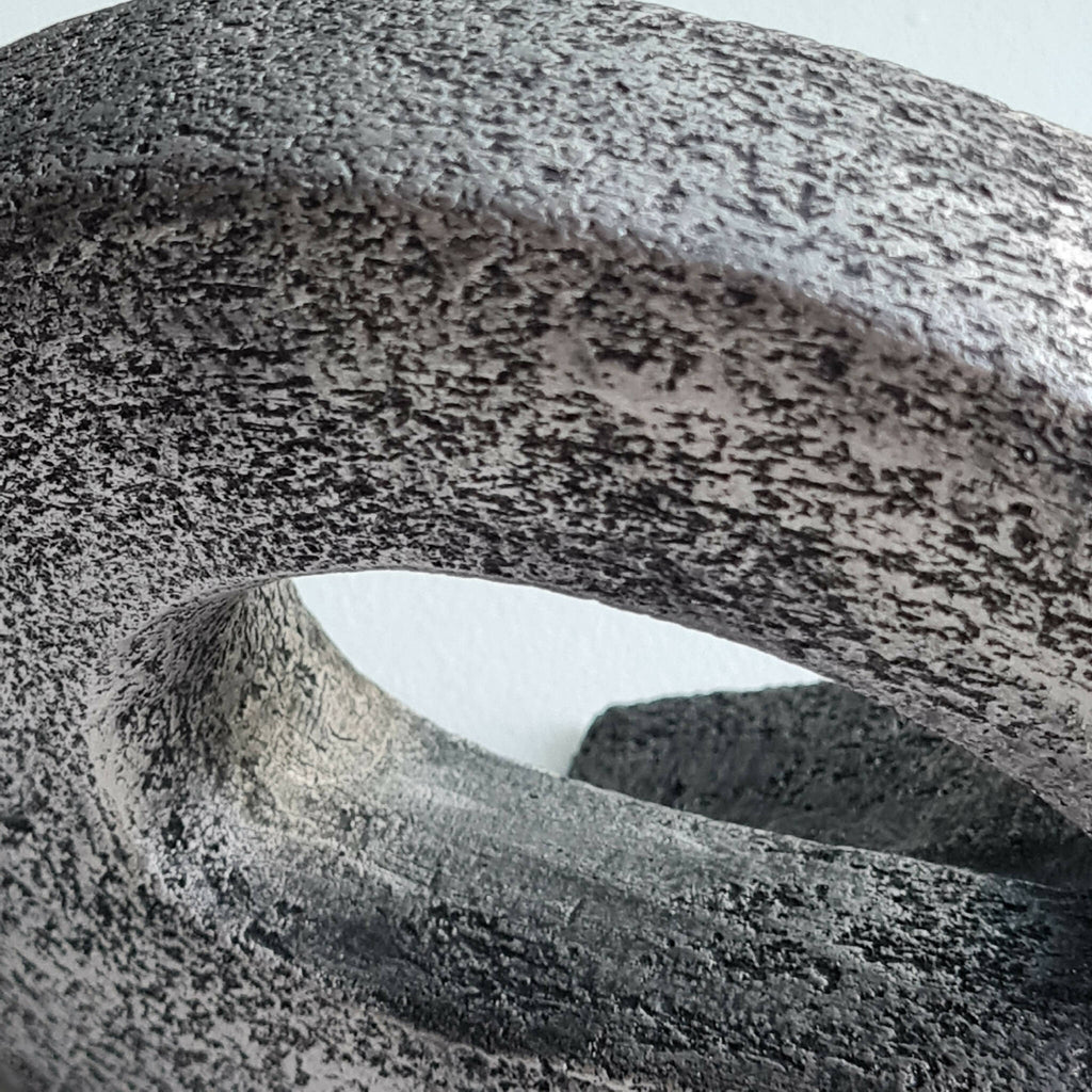 Sculpture en pierre sombre, gros plan de l’ouverture ovale et de la texture