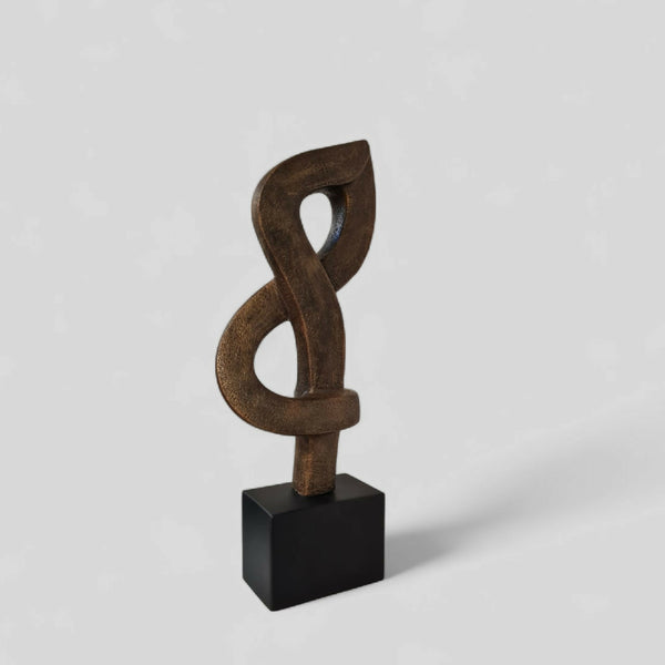 Sculpture abstraite en argile brun foncé, nœud entrelacé, sur socle noir.
