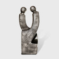 Sculpture de couple en métal gris patiné, deux silhouettes entrelacées sur socle