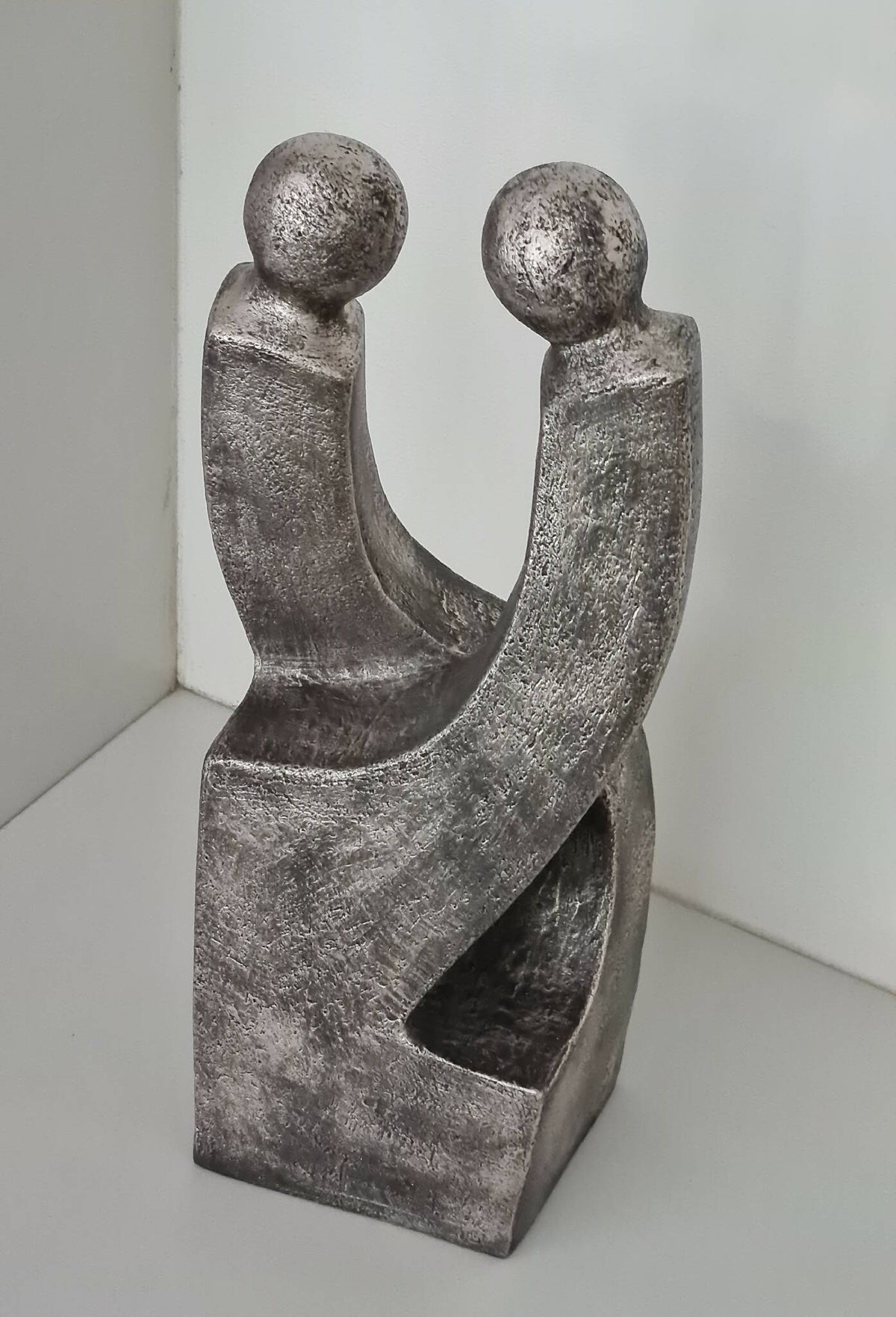 Sculpture de couple en métal gris argenté patiné, deux figures aux bras enserrés