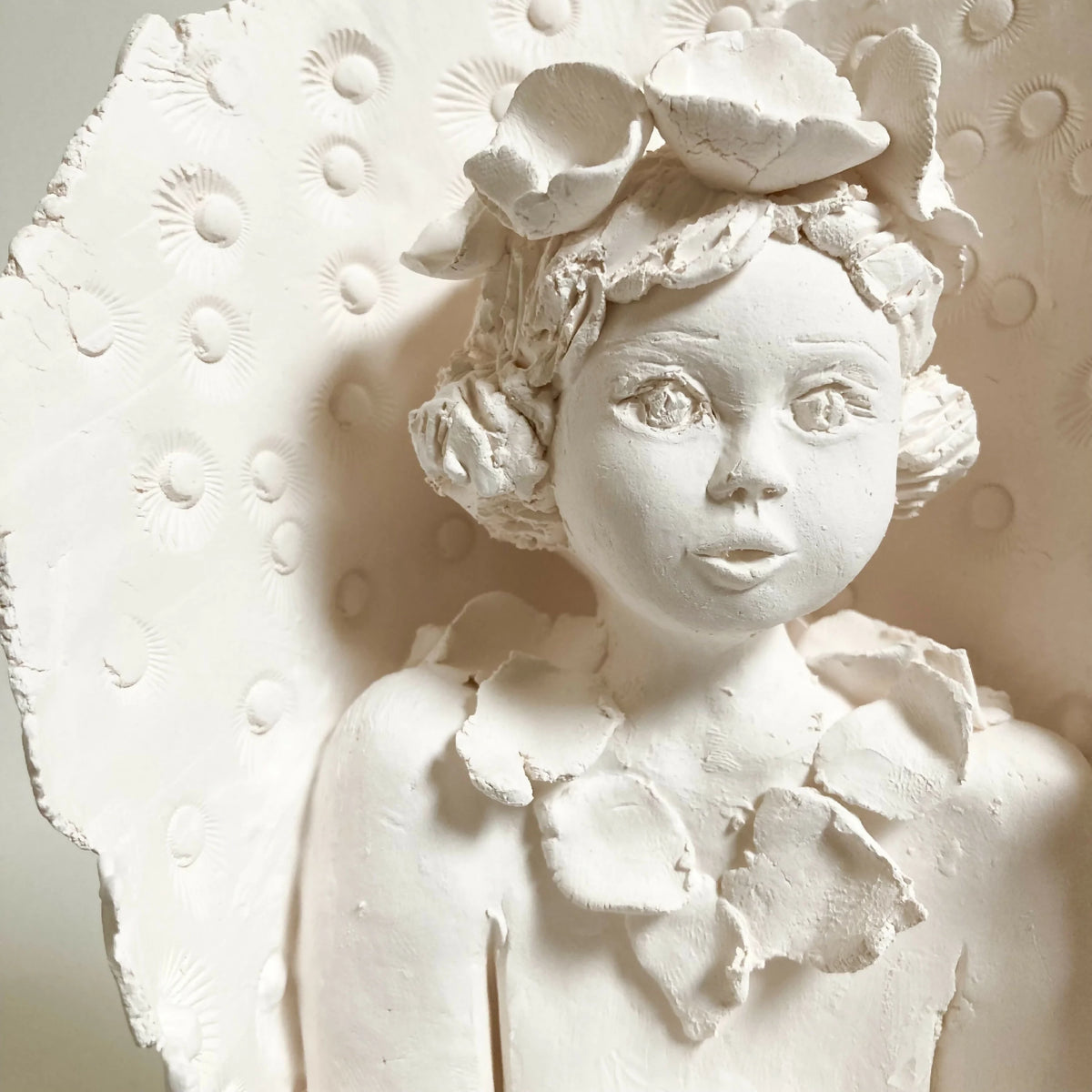 Sculpture femme à l’oiseau en relief, gros plan du visage et de l’oiseau sur la tête, blanche