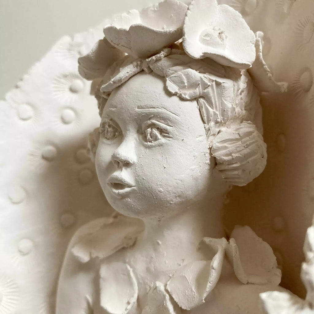 Sculpture femme à l’oiseau en relief, gros plan du visage avec oiseau et motifs, blanche