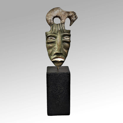 Masque sculpté bronze vert sur socle noir, face tournée de trois-quarts