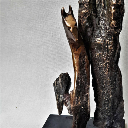 Sculpture figurative en métal patiné, personnage debout avec long bras et socle