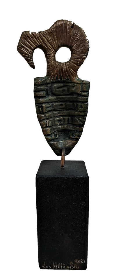 Masque sculpté bronze vert sur socle noir, vue de face et pied d’inscription