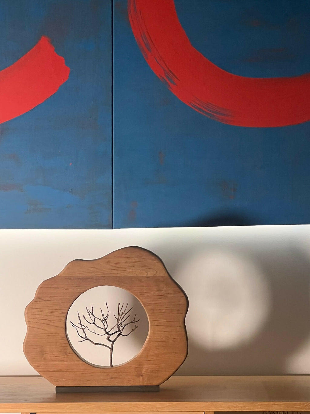Sculpture en bois florale avec médaillon rond, arbre noir sur fond clair