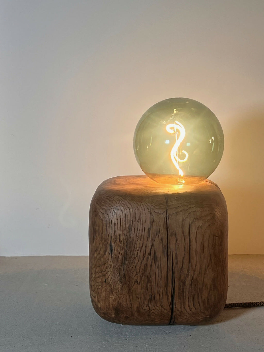 Sculpture lumineuse CUBE SPHERE : globe en verre vert sur bloc brun en bois
