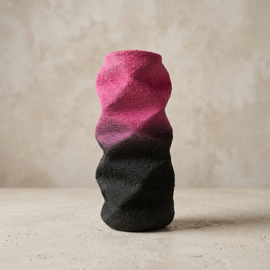 Petite sculpture abstraite bicolore rose et noire, surface texturée.