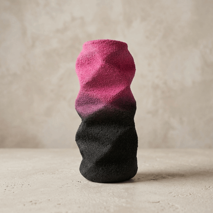 Petite sculpture abstraite bicolore rose et noire, surface texturée.