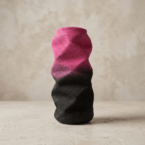 Petite sculpture abstraite bicolore rose et noire, surface texturée.