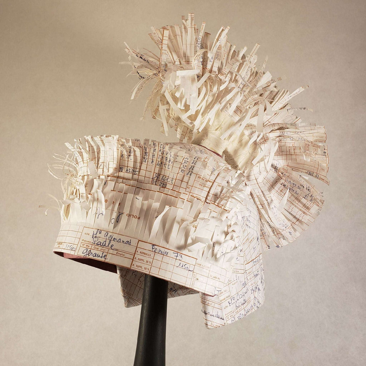Casque à aigrette beige en papier imprimé, vue de côté avec franges en papier.