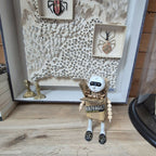 Sculpture bonhomme en carton exposé en vitrine murale, tête blanche et chaussures léopard